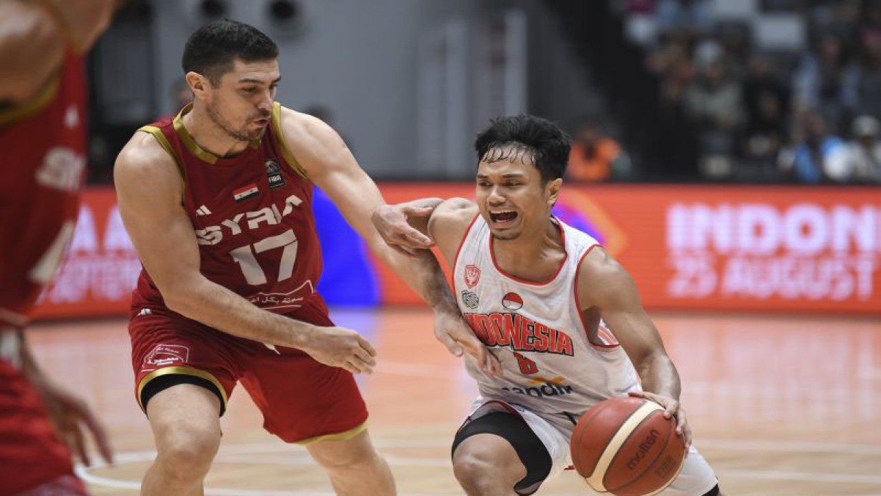 Pebasket Timnas Indonesia Yudha Saputera (kanan) berusaha melewati hadangan pebasket Timnas Suriah Emiliano Basabe (kiri) dalam laga Indonesia International Basketball Invitational (IIBI) 2023 di Indonesia Arena, Senayan, Jakarta, Sabtu (5/8/2023). . ANTARA FOTO/M Risyal Hidayat/aww. (ANTARA FOTO/M RISYAL HIDAYAT)