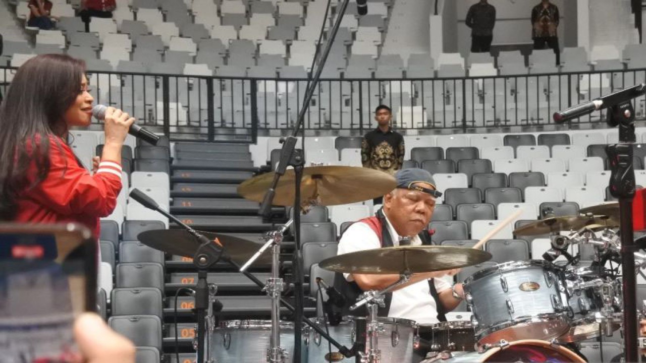 Menteri PUPR Basuki Hadimuljono diminta bermain drum bersama band Cokelat di depan Presiden Joko Widodo dalam peresmian Indonesia Arena, Jakarta, Senin (7/8/2023). (ANTARA/Indra Arief Pribadi)