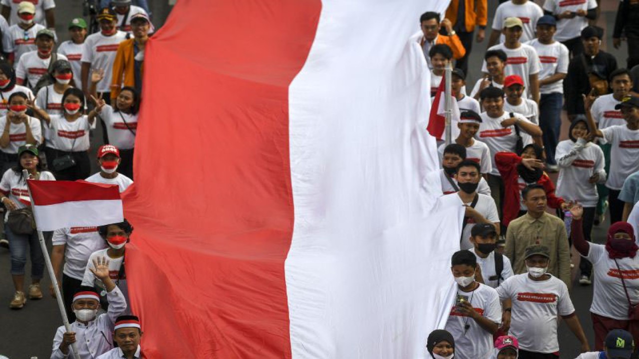 Sejumlah peserta membentangkan Bendera Merah Putih di kawasan Thamrin, Jakarta, Minggu (28/8/2022). Sebanyak 50.000 orang membentangkan bendera merah putih sepanjang 1.700 meter dari kawasan Monas hingga Bundaran Hotel Indonesia dalam rangka memperingati HUT ke-77 Kemerdekaan Republik Indonesia bertemakan 'Pulih Lebih Cepat, Bangkit Lebih Kuat. ANTARA FOTO/M Risyal Hidayat/foc.