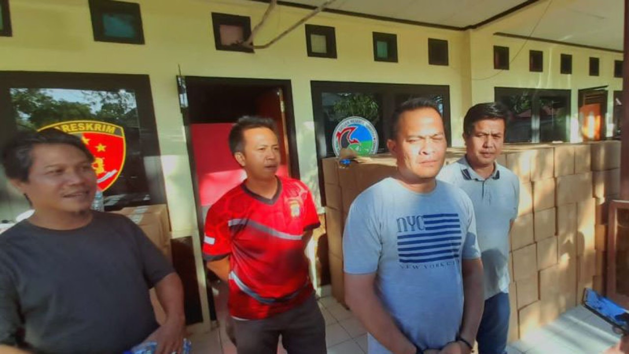 Personel Kepolisian saat menurunkan barang bukti minuman keras hasil sitaan Satuan Reserse Narkoba Polres Bone Bolango. (ANTARA/Zulkifli Polimengo).