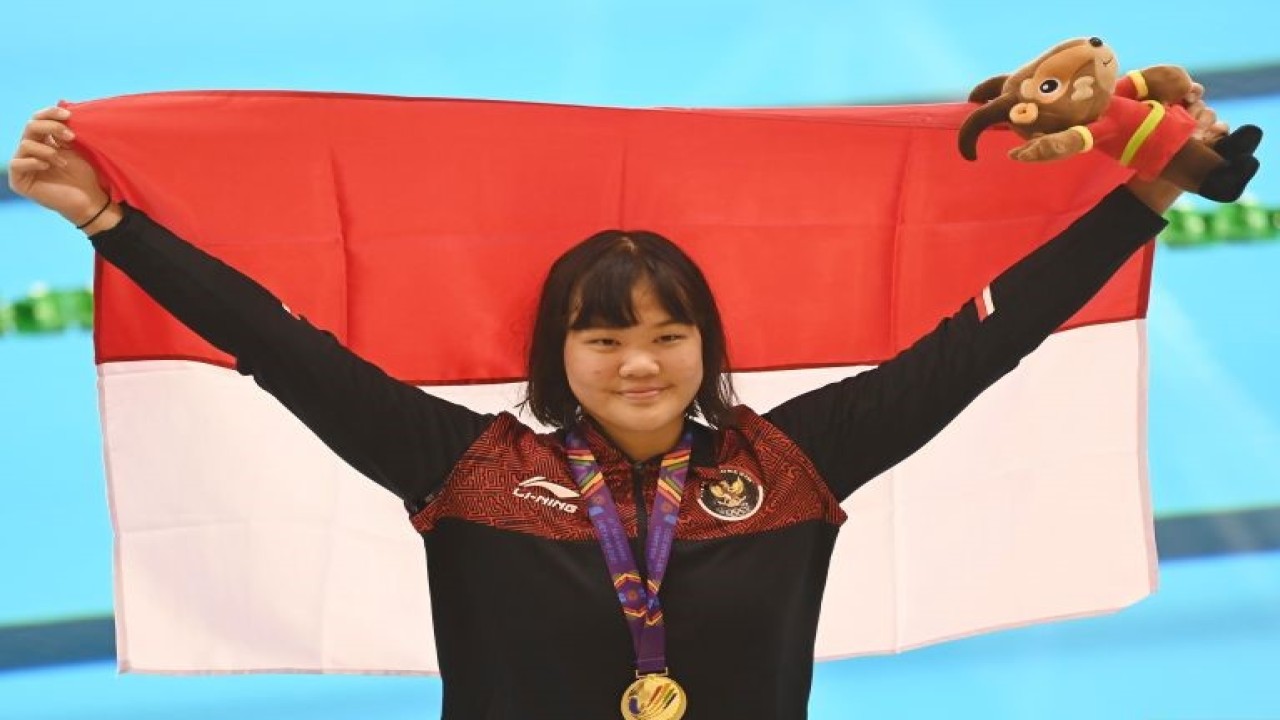 Arsip - Perenang Indonesia Flairene Candrea Wonomiharjo membentangkan bendera Merah Putih usai upacara pengalungan medali nomor renang 100 meter gaya punggung putri SEA Games 2021 Vietnam di Aquatic Sport Palace, Hanoi, Vietnam, Selasa (17/5/2022). . ANTARA FOTO/Aditya Pradana Putra/rwa.