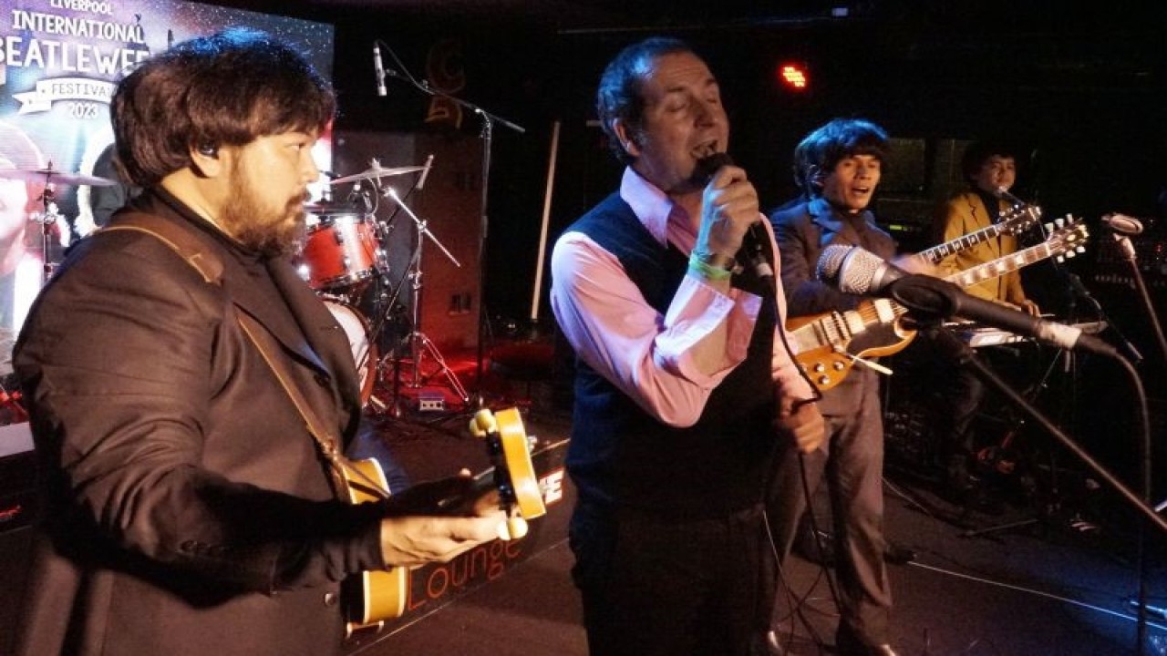 Band tribute The Beatles G-Pluck mengajak seorang penonton untuk bernyanyi bersama di atas panggung Cavern Live Lounge pada perhelatan Liverpool International Beatleweek Festival 2023, Senin (28/8). (ANTARA/Ahmad Faishal)