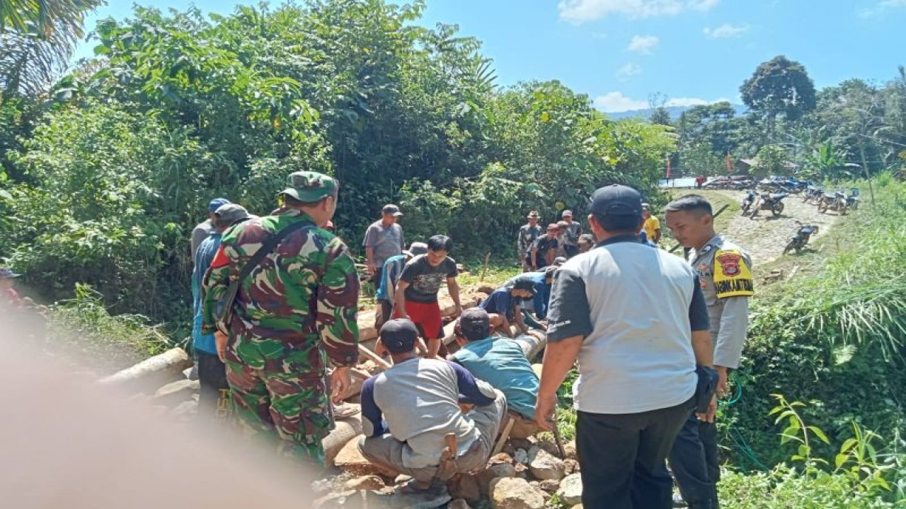 Suasana saat sejumlah anggota polisi dan TNI bersama warga bergotong royong membangun jembatan. ANTARA/HO-Humas Polres Pesisir Barat
