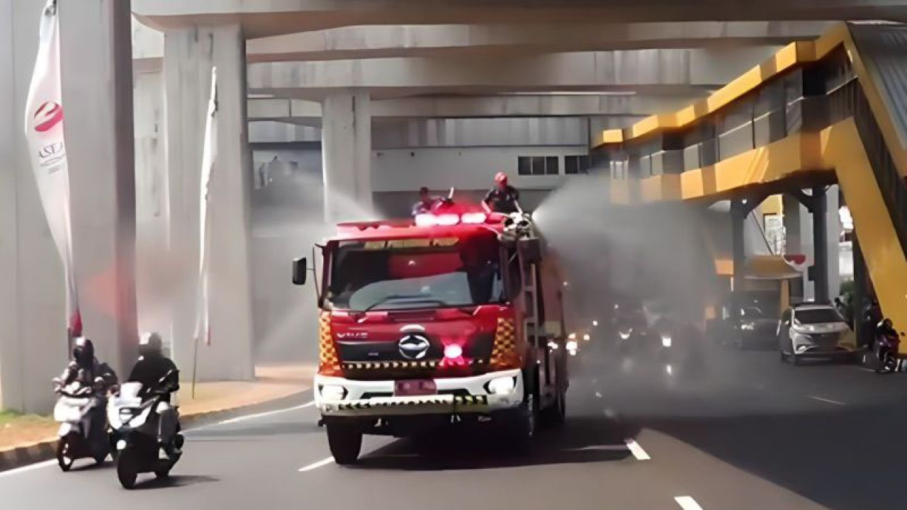 Mobil dari Sudin Penanggulangan Kebakaran dan Penyelamatan (Gulkarmat) Jakarta Timur melakukan penyemprotan air di Jalan MT Haryono, Cawang, Jakarta Timur untuk mengendalikan polusi udara di Jakarta, Jumat (25/8/2023). ANTARA/Syaiful Hakim