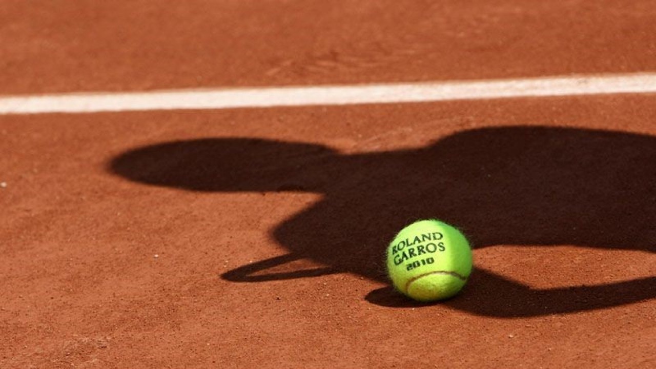 ilustrasi - Bola resmi turnamen tenis dengan bayang-bayang seorang pemain tenis diatas tanah. ANTARA/Shutterstock/pri.