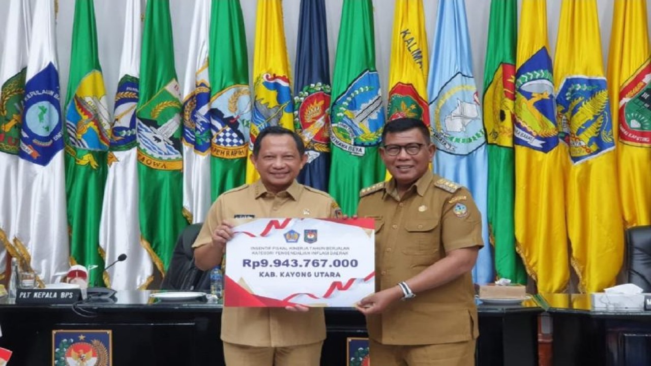 Menteri Dalam Negeri Tito Karnavian (kanan) menyerahkan penghargaan kepada Bupati Kayong Utara Citra Duani (kiri) dalam rangka penghargaan pemerintah daerah dengan kinerja terbaik tingkat nasional dalam rangka pengendalian inflasi daerah Tahun 2023. ANTARA/HO-Prokopim Setda Kayong Utara.