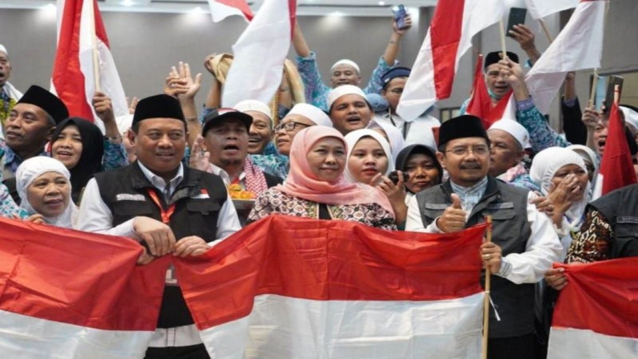 Gubernur Jawa Timur Khofifah Indar Parawansa (tengah) berpose usai membagikan Bendera Merah Putih kepada jamaah haji di Asrama Haji Debarkasi, Surabaya, Jawa Timur, Jumat (4/8/2023). (ANTARA/HO-Kanwil Kemenag Jatim)