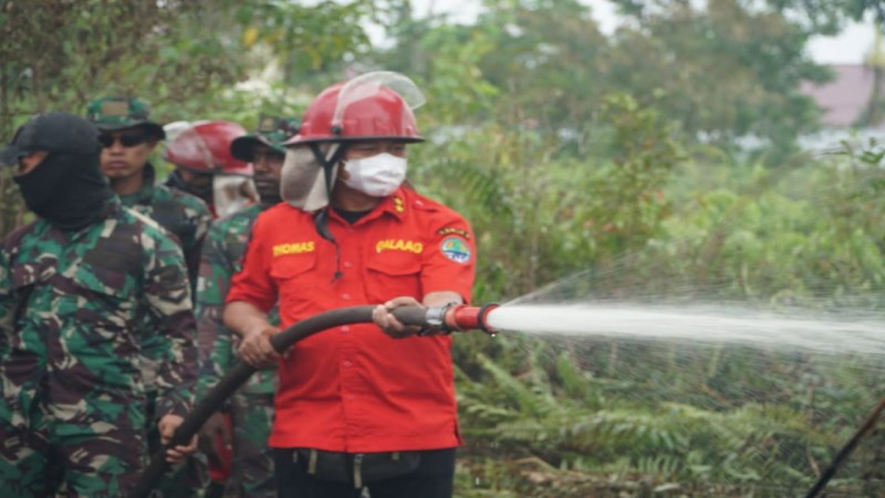 Direktur Pengendalian Kebakaran Hutan dan Lahan KLHK Thomas Nifinluri (kanan) menyemprotkan air untuk memadamkan api yang membakar hutan dan lahan di Kalimantan Barat. (ANTARA/HO-Kementerian LHK)