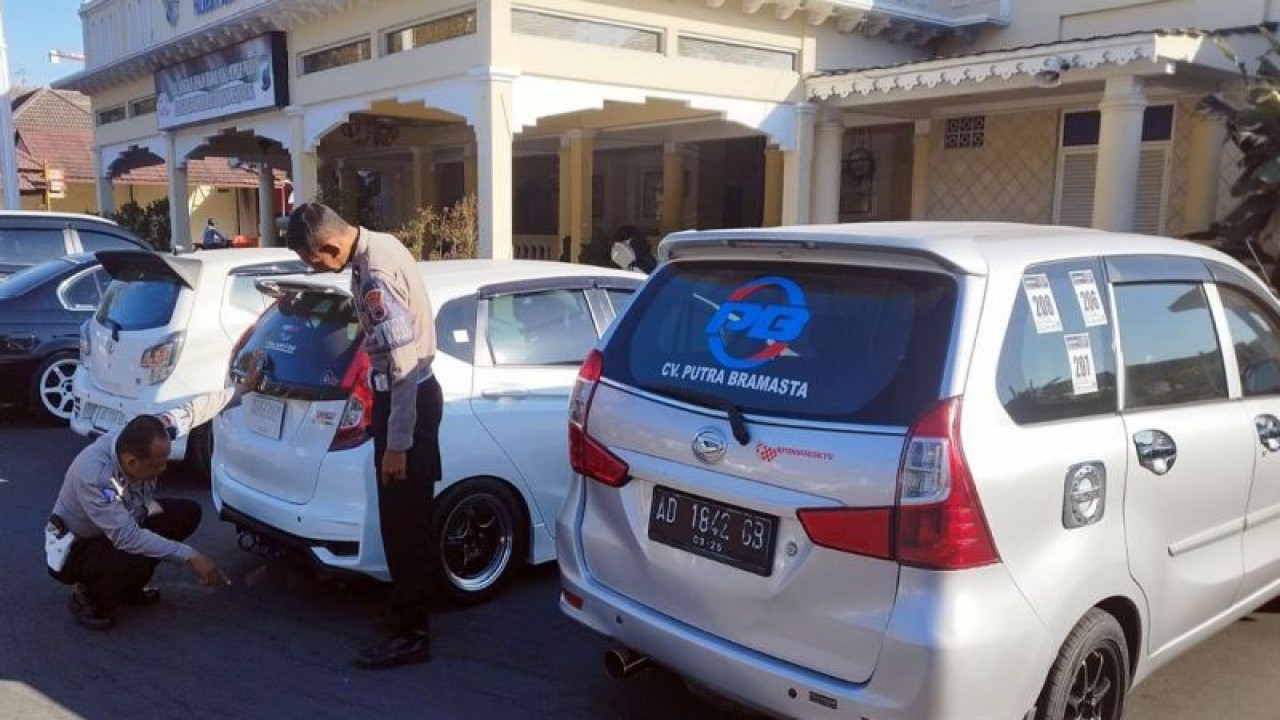 Sejumlah petugas polisi memeriksa surat dokumen mobil yang menggunakan knalpot brong di halaman Mapolresta Surakarta, Jawa Tengah, Rabu (16/8/2023). ANTARA/Bambang Dwi Marwoto