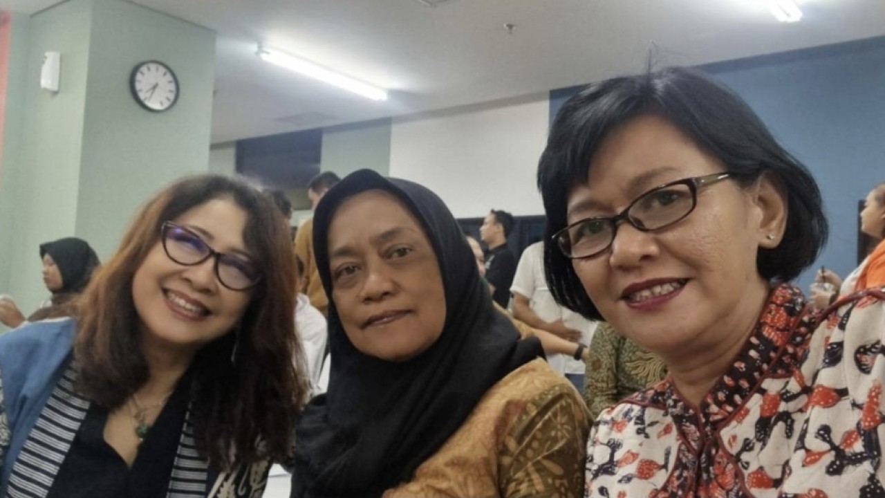 Kusuma Wardani (tengah) memakai kerudung hitam