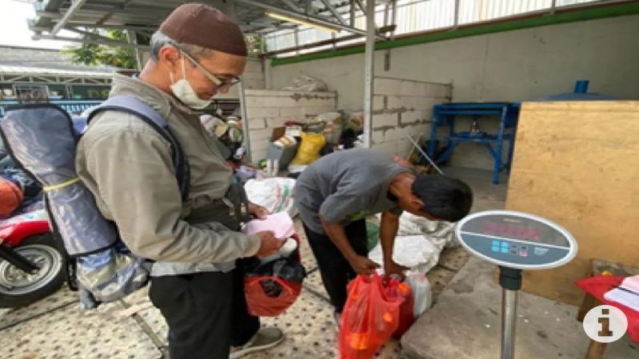 Seorang warga sedang menukarkan limbah minyak bekas di Bank Sampah Gunung Emas Cakung, Jakarta Timur, Senin (7/8/2023). (ANTARA/Arif Prada)