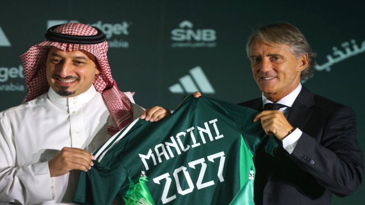 Presiden Federasi Sepak Bola Arab Saudi Yasser al-Misehal (kiri) dan pelatih baru timnas Arab Saudi Roberto Mancini (kanan) berpose untuk difoto pada konferensi pers dan penandatanganan kontrak kerja di Riyadh, Arab Saudi, Senin (28/8/2023). (AFP/FAYEZ NURELDINE)
