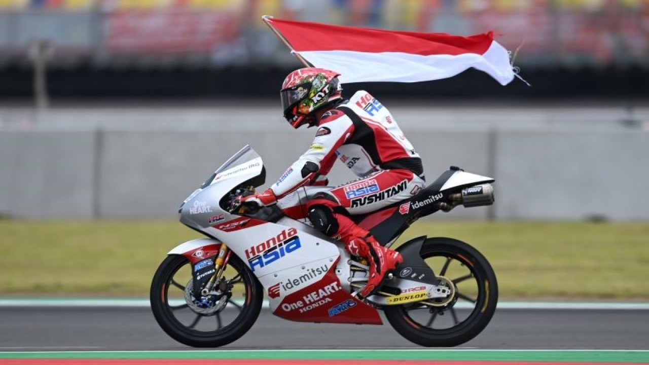 Arsip - Pembalap Honda Team Asia Mario Suryo Aji membawa bendera merah putih seusai balapan Moto3 seri Pertamina Grand Prix of Indonesia di Pertamina Mandalika International Street Circuit, Lombok Tengah, NTB, Minggu (20/3/2022). ANTARA FOTO/Andika Wahyu/YU
