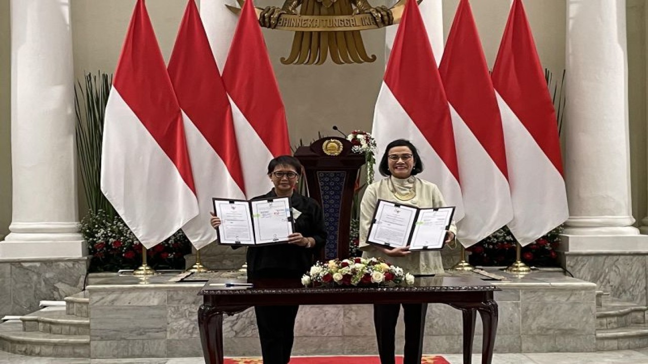 Menlu Retno Marsudi (kiri) dan Menkeu Sri Mulyani Indrawati (kanan) menunjukkan MoU Kerja Sama di Bidang Keuangan Negara dan Hubungan Luar Negeri untuk Mendukung Diplomasi Ekonomi usai penandatanganan di Gedung Pancasila, Jakarta, pada Senin (14/8/2023). (ANTARA/Yashinta Difa)