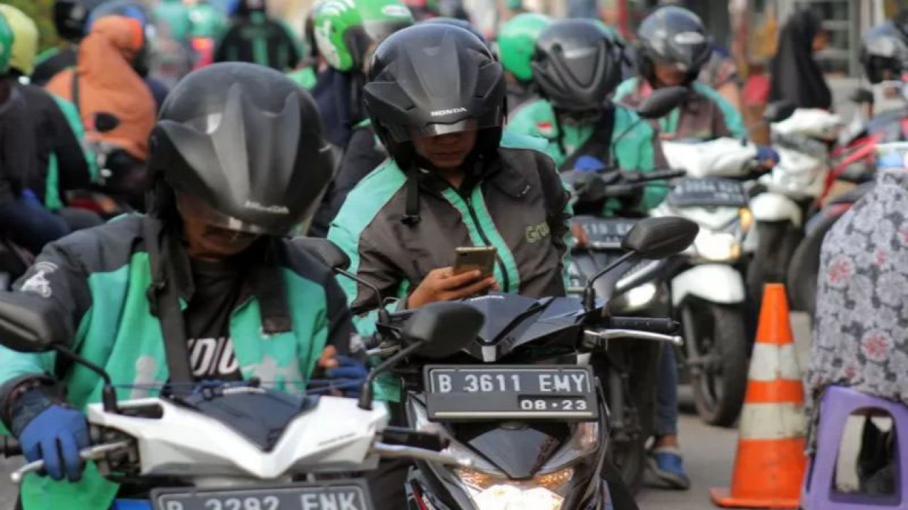 Sejumlah pengemudi ojek daring (online) menunggu penumpang. (ANTARA FOTO/Yulius Satria Wijaya)