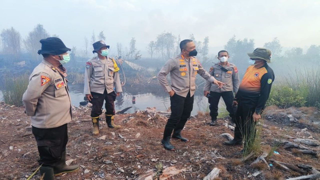 Kapolresta Palangka Raya Kombes Pol Budi Santosa (tiga dari kanan) berkomunikasi dengan personel BPBD Kota Palangka Raya di lokasi karhutla di Kelurahan Petuk Katimpun, Rabu (30/8/2023). ANTARA/Humas Polresta Palangka Raya.