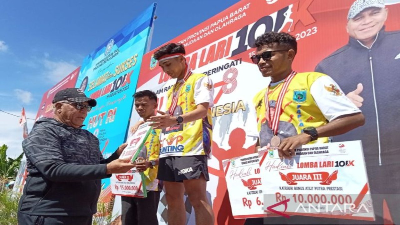 Penjabat Gubernur Papua Barat Paulus Waterpauw menyerahkan medali dan hadiah kepada tiga juara lomba lari 10 kilometer kategori prestasi putra di Manokwari, Selasa. (ANTARA/Fransiskus Salu Weking)