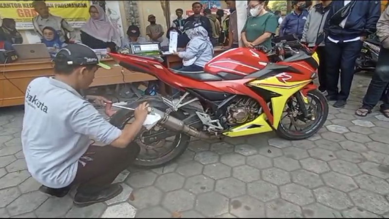 Teknisi uji emisi memasukkan alat uji ke dalam knalpot kendaraan roda dua milik pengendara yang mengikuti kegiatan uji emisi gratis di halaman Kantor Kecamatan Pademangan, Jakarta Utara, Rabu (30/8/2023). ANTARA/HO-Dokumentasi Pribadi Didit Mulyadi