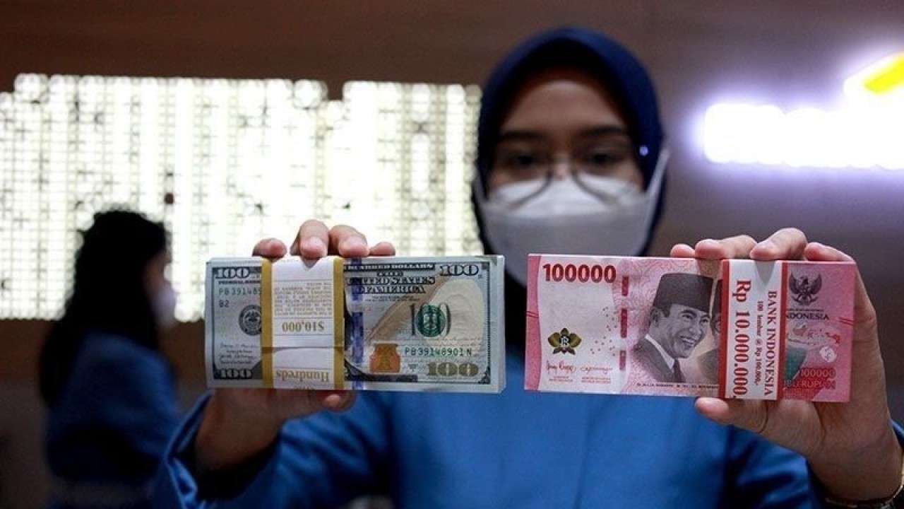 Ilustrasi - Petugas menunjukkan uang dolar AS dan uang rupiah di salah satu kantor cabang PT. Bank Mandiri Persero Tbk, Jakarta, Selasa (31/1/2023). ANTARA FOTO/Reno Esnir/tom/pri.