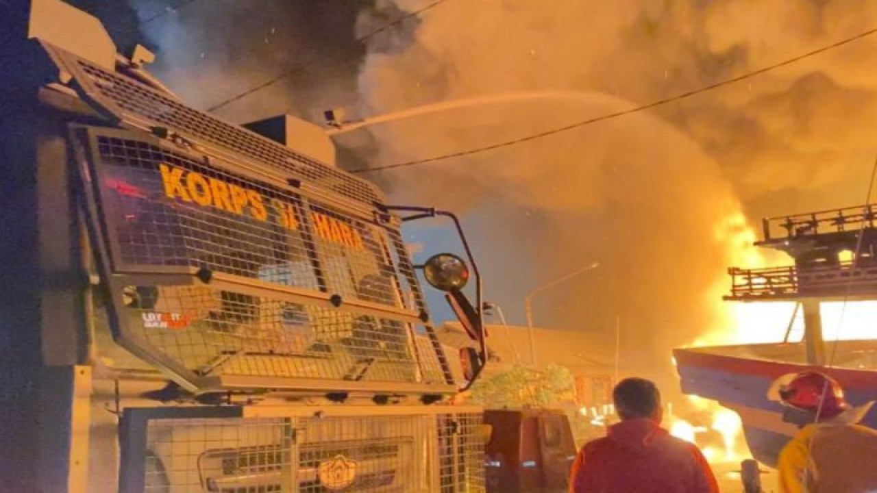 Petugas gabungan berupaya memadamkan api yang membakar puluhan kapal di Pelabuhan Jongor, Kota Tegal, Selasa (14/8) malam. (ANTARA/ HO-Polres Tegal Kota)
