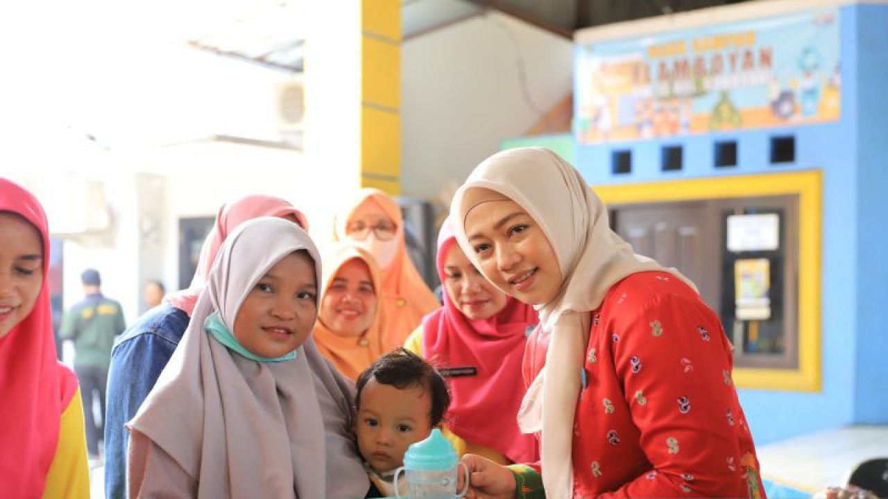 Ketua TP PKK Kota Tangerang, Aini Suci Wismansyah (kanan) menghadiri kegiatan Pemberian Makanan Tambahan (PMT) kepada warga di Balai Warga Kelurahan Sukasari Tangerang, Senin. DIrinya memberikan imbauan kepada orang tua agar membuat makanan sehat di rumah dalam menjaga tumbuh kembang anak kedepannya. ANTARA/Irfan