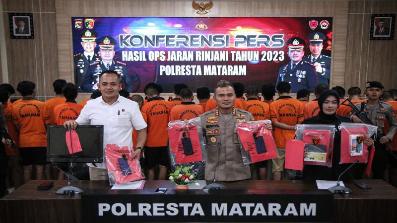 Kapolresta Mataram Kombes Pol. Mustofa (tengah) bersama Kepala Satreskrim Polresta Mataram Kompol Made Yogi (kiri) menunjukkan barang bukti dan tersangka hasil ungkap kasus kejahatan jalanan dalam periode giat Operasi Jaran Rinjani 2023 di Mataram, NTB, Rabu (16/8/2023). (ANTARA/Dhimas B.P.)