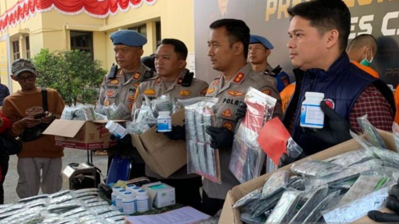 Kapolres Cianjur, Jawa Barat, AKBP Aszhari Kurniawan didampingi Kasatnarkoba Polres Cianjur, AKP Primadona memperlihatkan puluhan ribu butir obat terlarang yang diamankan dari tiga tersangka, Rabu (23/8/2023).(ANTARA/Ahmad Fikri). (Ahmad Fikri)