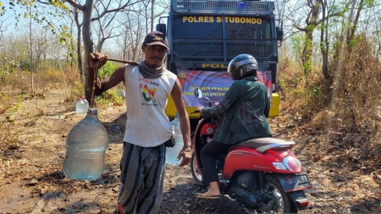Seorang warga Dusun Langai, Desa Sumberkolak, Kecamatan Panarukan, Situbondo, Jatim, memikul air bersih bantuan Polres setempat. Kamis (3/8/2023) ANTARA/Novi Husdinariyanto