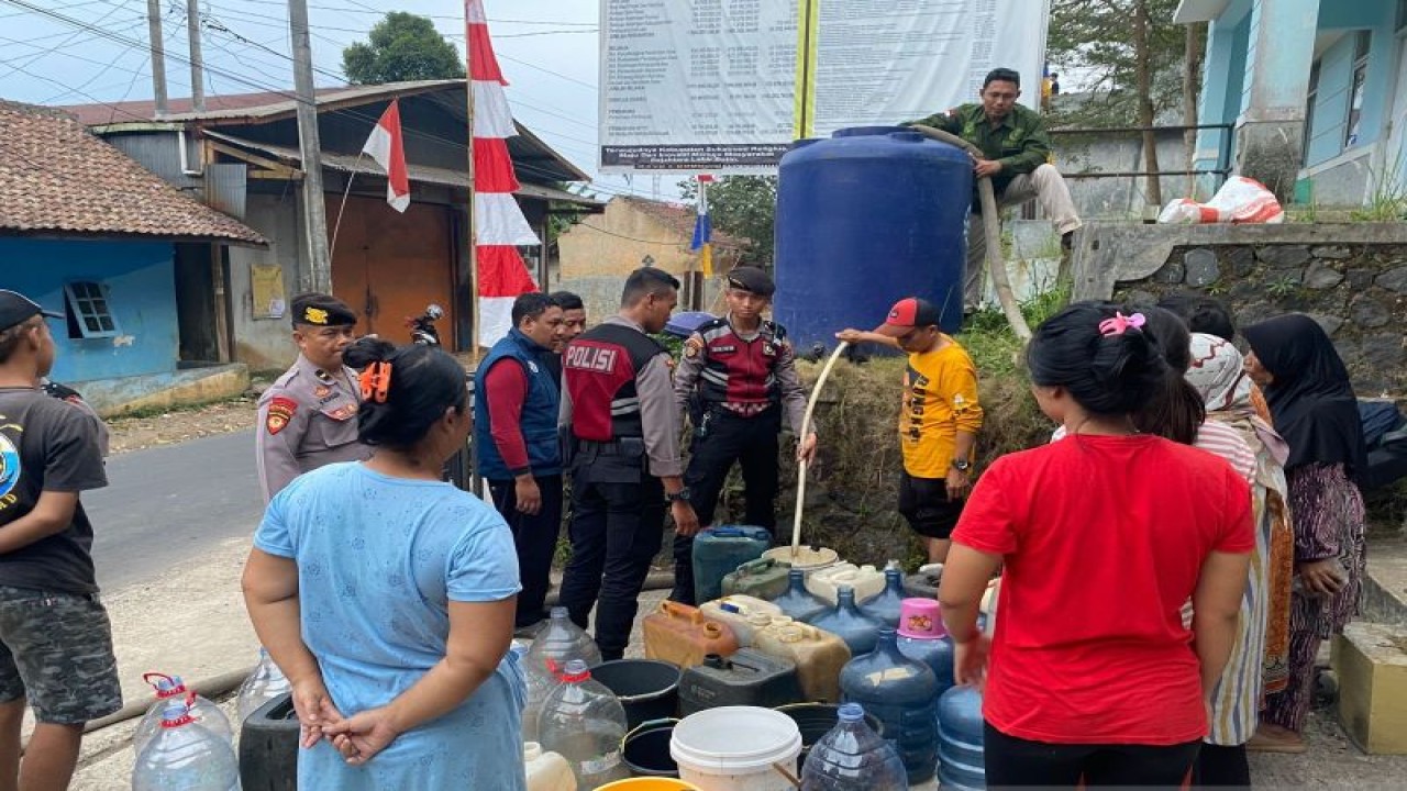 Warga Kampung Ciroyom, Desa Padaasih, Kecamatan Cisaat, Kabupaten Sukabumi, Jawa Barat antre untuk mendapatkan air bersih yang disalurkan Polres Sukabumi Kota pada Kamis, (10/8). Antara/Aditya Rohman