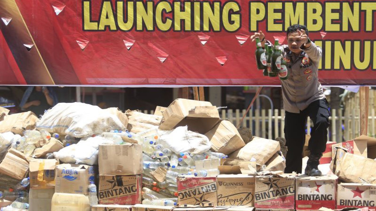 Anggota Polri melempar minuman beralkohol ke dalam lubang di Polres Bone Bolango, Kabupaten Bone Bolango, Gorontalo, Senin (28/8/2023). ANTARA/Adiwinata Solihin