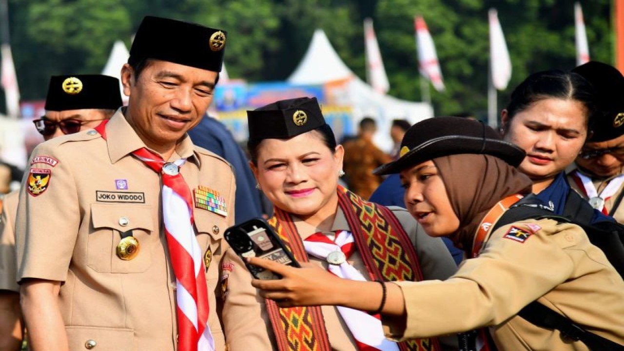 Presiden Joko Widodo dan Ibu Negara Iriana Joko Widodo diajak berswafoto oleh seorang anggota Pramuka ketika meninjau kegiatan Raimuna Nasional XII Gerakan Pramuka Tahun 2023 di Cibubur, Jakarta, pada Selasa (15/8/2023). (ANTARA/HO-Biro Pers Sekretariat Presiden)