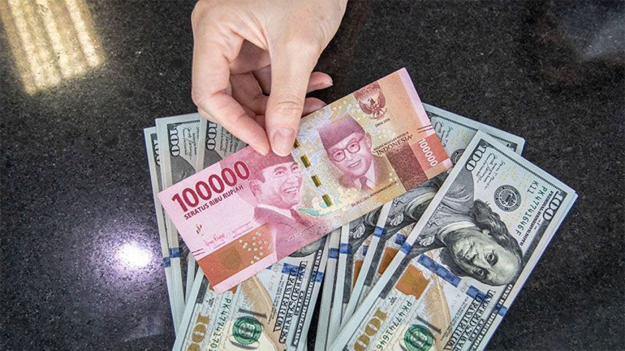Dokumentasi - Petugas menunjukan uang pecahan rupiah dan dolar AS di gerai penukaran mata uang asing VIP (Valuta Inti Prima) Money Changer, Jakarta. ANTARA FOTO/Muhammad Adimaja/aww/pri.