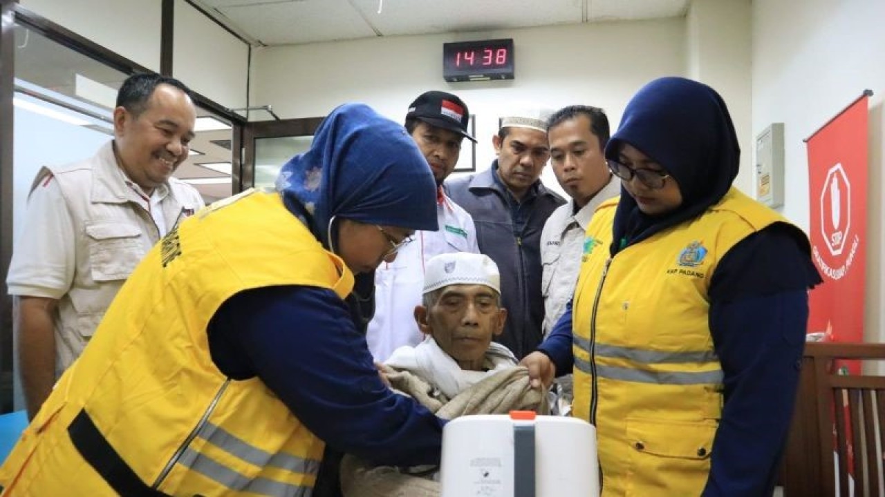 Petugas memeriksa kesehatan seorang haji Debarkasi Padang Sumatera Barat yang tergabung pada kelompok terbang (kloter) lima asal Kabupaten Limapuluh Kota. (ANTARA/HO-Humas Kemenag Sumbar).