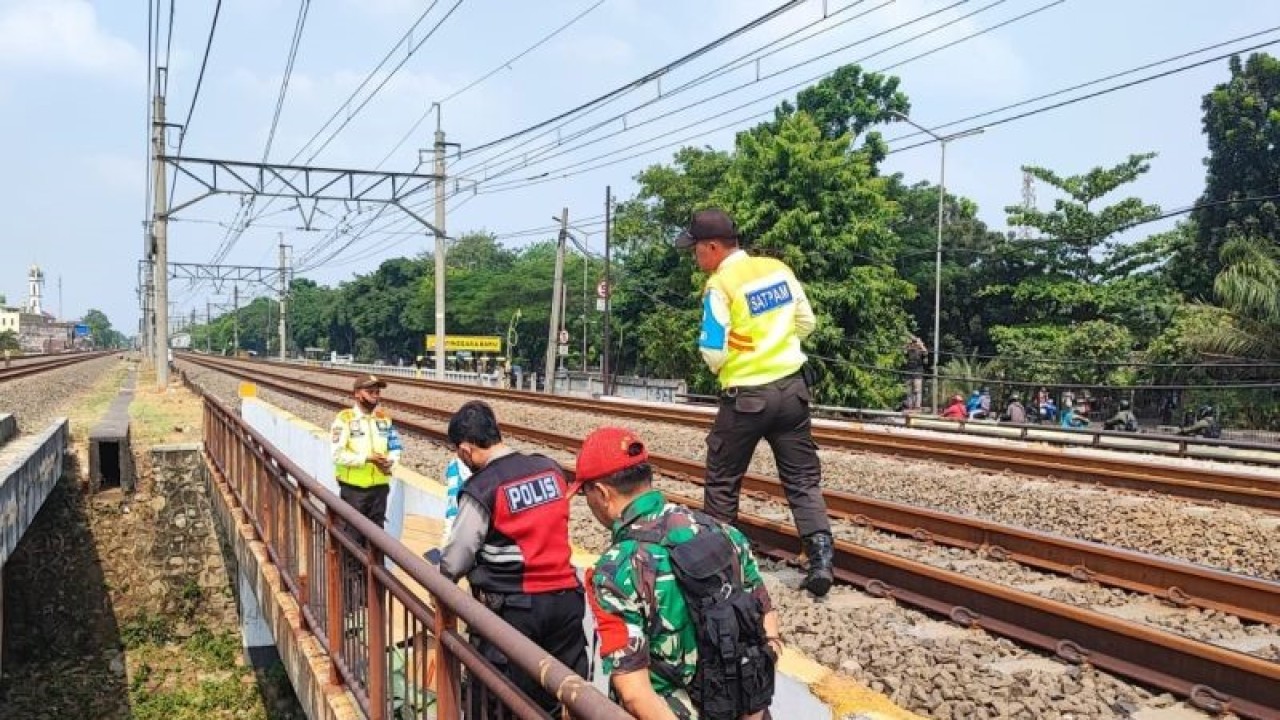 Petugas kepolisian dan petugas keamanan PT KAI tengah melihat korban tewas akibat tersambar kereta di dekat Stasiun Buaran, Kecamatan Cakung, Jakarta Timur, Senin (28/8/2023). ANTARA/Syaiful Hakim