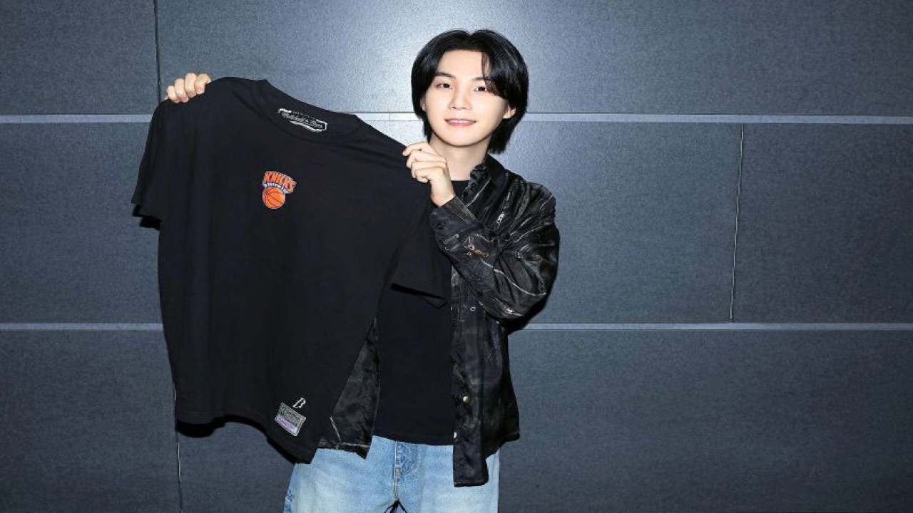 SUGA BTS berfoto bersama salah satu produk fesyen hasil kolaborasinya dengan NBA dan Mitchell & Ness. (ANTARA/HO/NBA Indonesia)