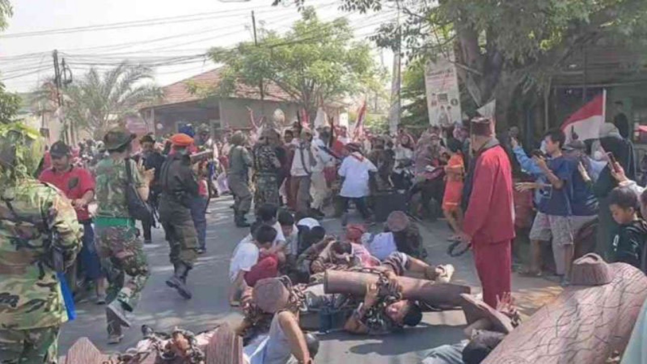 Aksi pemeran teatrikal jalanan berjudul Si Belut Putih di sepanjang Jalan Raya Haji Nausan hingga Suropati Kecamatan Tambun Utara, Kabupaten Bekasi, Jawa Barat, Sabtu. (ANTARA/Pradita Kurniawan Syah).