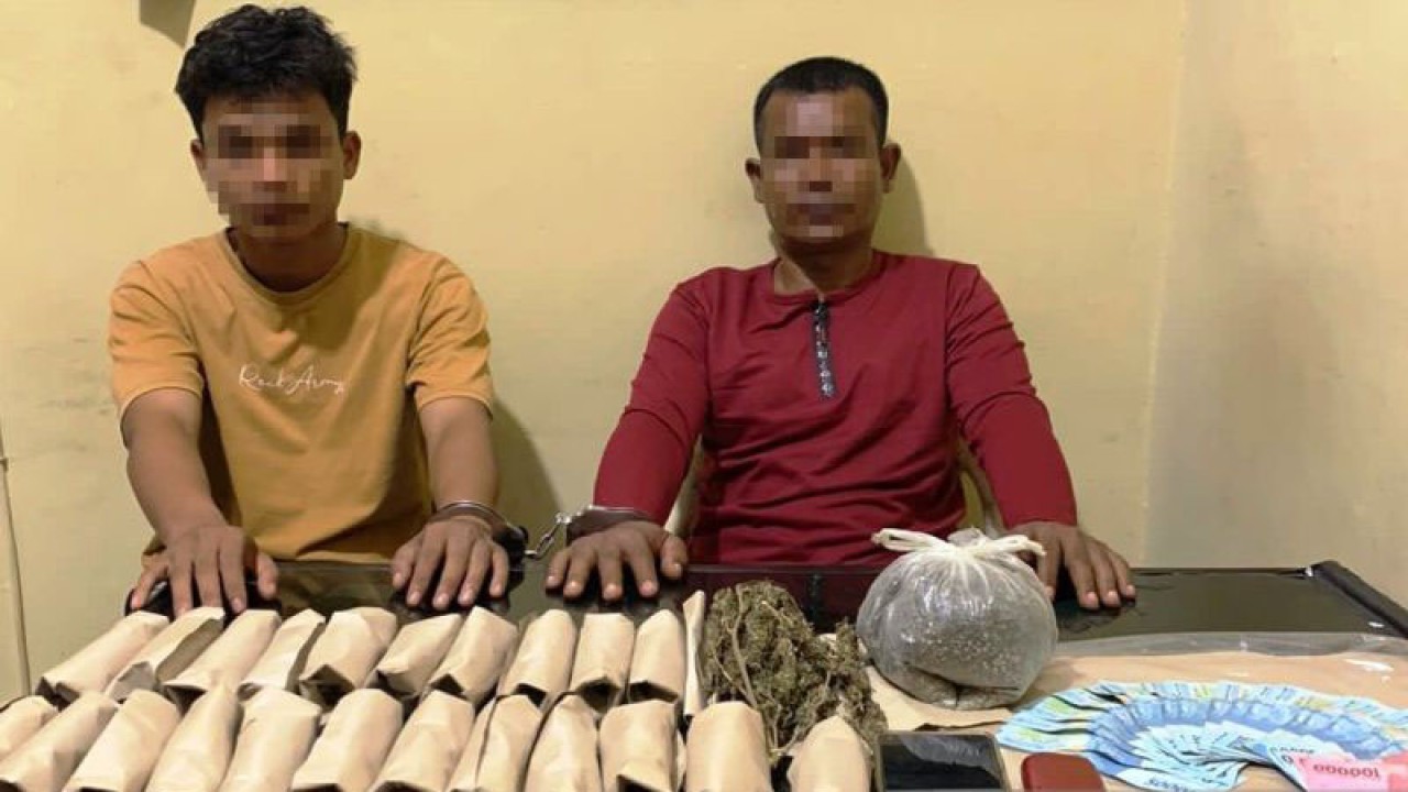 Polisi memperlihatkan dua tersangka diduga pengedar narkotika jenis ganja saat diamankan di Satuan Reserse Narkoba Polres Aceh Barat di Meulaboh, Rabu (2/8/2023). (ANTARA/HO-Dok Humas Polres Aceh Barat)