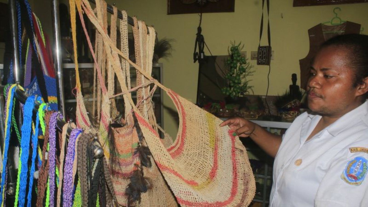 Penanggung jawab galeri Dinas Koperasi dan Usaha Mikro Kecil Menengah (Diskop dan UMKM) Kabupaten Jayapura Yuni Mara saat menunjukan salah satu suvenir noken di gelari UMKM, Senin 28 Agustus 2023 (ANTARA/Yudhi Efendi)