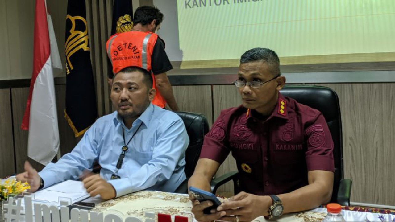 Kepala Kantor Imigrasi Mataram Pungki Handoyo (kanan) menghadirkan WNA asal Prancis inisial GG yang melanggar izin tinggal dengan bekerja sebagai kontraktor di Lombok Tengah dalam konferensi pers di Mataram, Kamis (10/8/2023). (ANTARA/Dhimas B.P.)