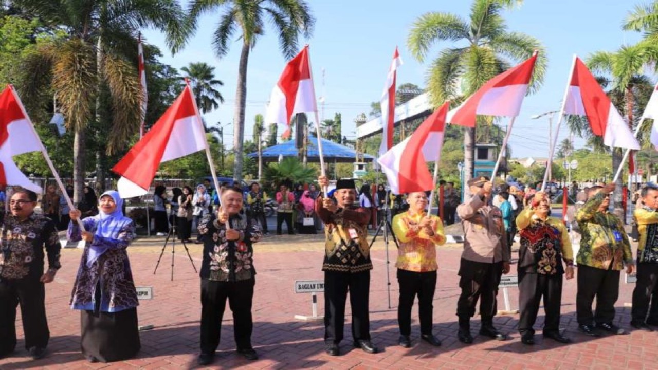 Penjabat (Pj) Bupati Hulu Sungai Utara (HSU) Zakly Asswan (keempat kiri) membuka secara simbolis pembagian ribuan bendera merah putih kepada masyarakat, di Amuntai, Hulu Sungai Utara, Kalimantan Selatan, Kamis (10/8/2023). (ANTARA/HO-Pemkab HSU)