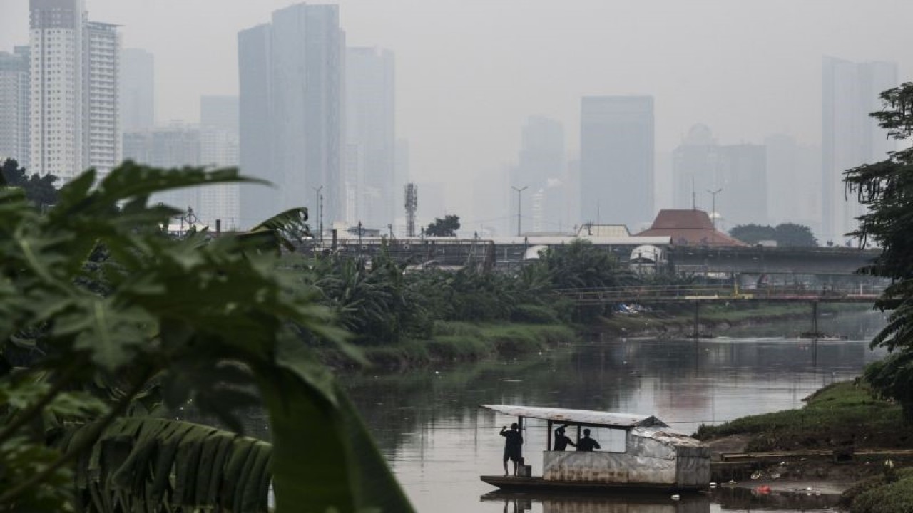 Arsip Foto - Kapal eretan menyeberangi aliran Kanal Banjir Barat dengan latar belakang deretan gedung bertingkat tersamar kabut polusi udara di Jakarta, Jumat (17/6/2022). ANTARA FOTO/Aprillio Akbar/foc