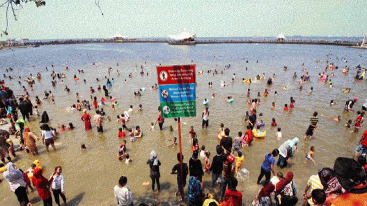 Wisatawan menikmati liburan kawasan pesisir di Pantai Ancol. ANTARA FOTO/Rivan Awal Lingga/foc