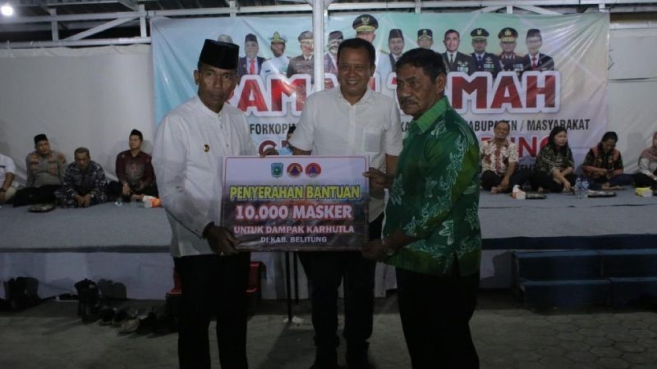 Penjabat Gubernur Kepulauan Bangka Belitung Suganda Pandapotan Pasaribu (kiri) membagikan 10.000 masker kepada Bupati Belitung di Desa Badau, Selasa (19/9/2023) malam. (ANTARA/HO-Diskominfo Babel)