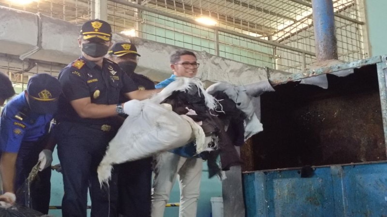 Kepala Kantor Bea Cukai Batam Ambang Priyonggo memasukkan sekarung pakaian bekas ke mesin penghancur, Kamis (14/9). (ANTARA/Yude)
