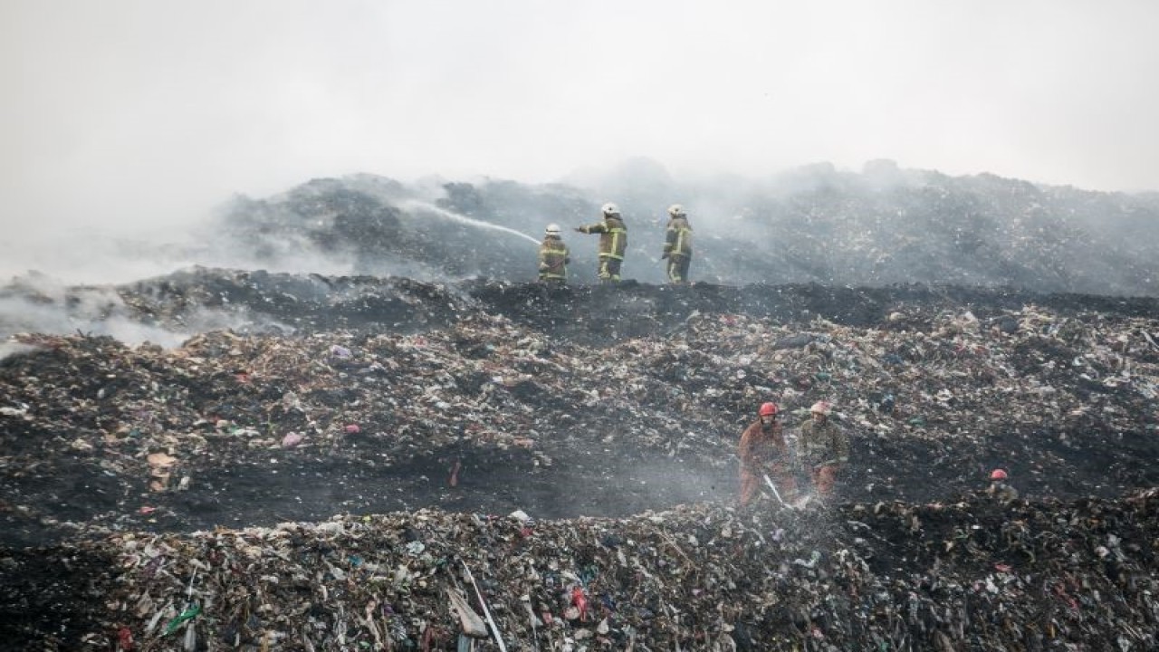 Petugas Pemadam Kebakaran berusaha memadamkan api yang membakar gunungan sampah di TPA Putri Cempo, Solo, Jawa Tengah, Minggu (17/9/2023). Kebakaran tersebut diduga karena cuaca panas yang memicu gas metan di dalam sampah, sedangkan luasan gunungan sampah yang terbakar diperkirakan mencapai dua hektar. ANTARA FOTO/Mohammad Ayudha/nz.