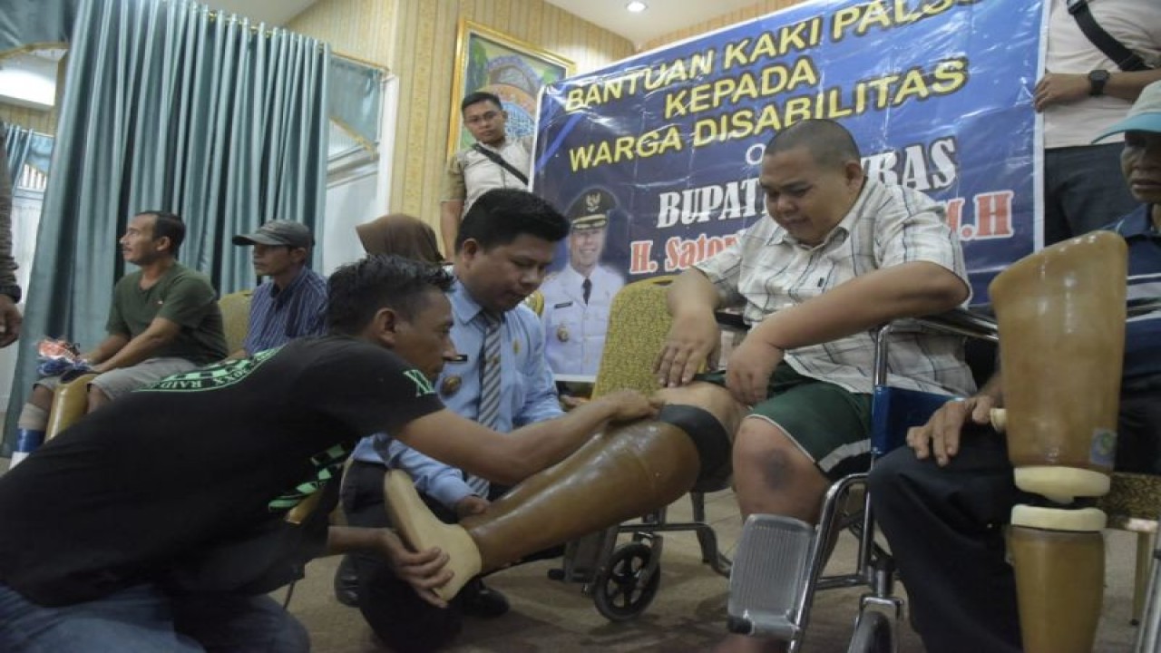 Bupati Sambas memberikan bantuan kaki palsu kepada penyandang disabilitas (ANTARA/Imbran)