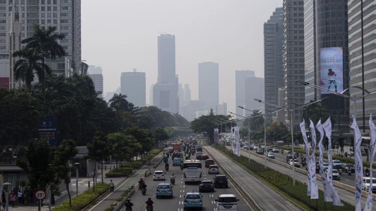 Kendaraan melintas dengan latar belakang gedung bertingkat yang terlihat berkabut di Jalan Jenderal Sudirman, Jakarta, Rabu (22/6/2022). ANTARA FOTO/Sigid Kurniawan/hp.