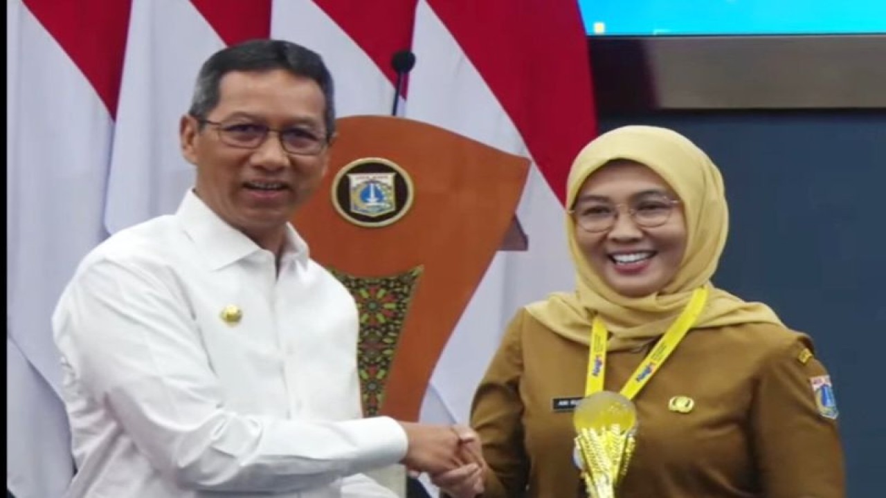 Penjabat (Pj) Gubernur DKI Jakarta Heru Budi Hartono menyerahkan piala kepada Pelaksana Tugas (Plt) Kepala Dinas Kesehatan (Dinkes) DKI Jakarta Ani Ruspitawati di Balai Kota DKI, Jakarta Pusat, Senin (25/9/2023). (ANTARA/HO-YouTube Pemprov DKI Jakarta)