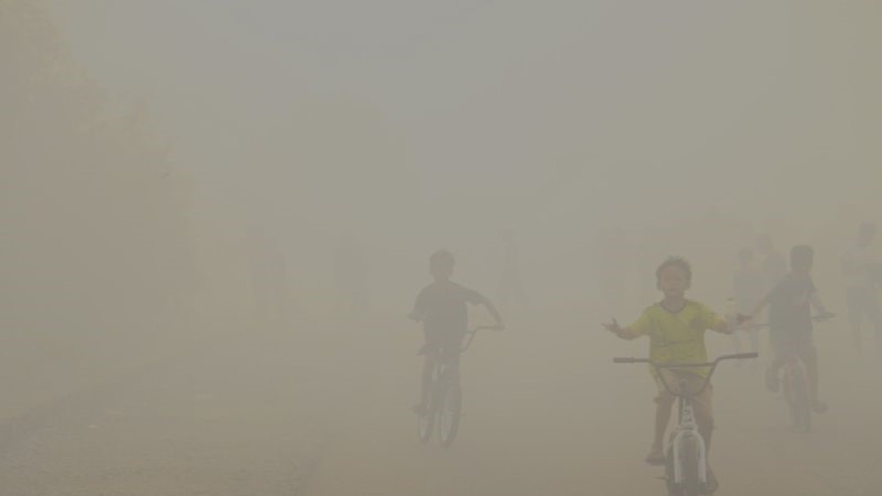 Anak-anak melintas di jalan dengan kondisi kepungan kabut asap sekitar kejadian kebakaran hutan dan lahan (karhutla) di Kelurahan Landasan Ulin Selatan, Kecamatan Liang Anggang, Kota Banjarbaru, Kalimantan Selatan, beberapa waktu lalu. ANTARA/Tumpal Andani Aritonang