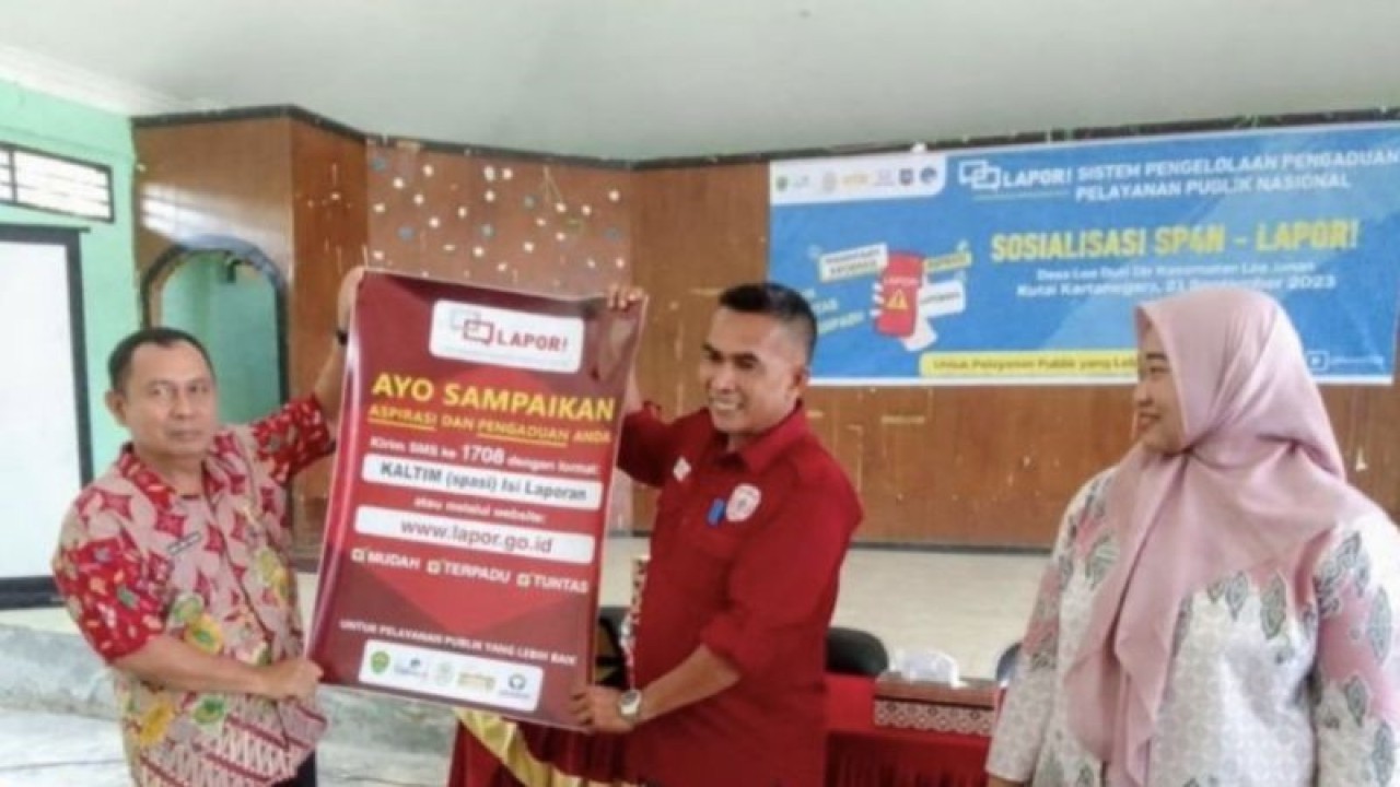 Pranata Humas Ahli Muda Diskominfo Kaltim Andi Abdul Razaq dan Kades Loa Duri Ilir saat membentang poster sosialisasi SP4N Lapor, di Desa Loa Duri Ilir, Kecamatan Loa Janan, Kabupaten Kutai Kartanegara, didampingi perwakilan Camat Loa Janan Sari Endah. ANTARA/Fandi
